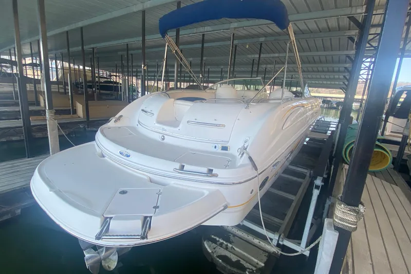 Slide: The Image of 2003 Chaparral Sunesta 263 boat docked under a covered marina with blue canopy. - 3