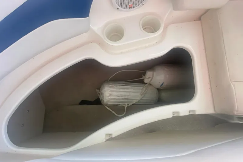 Slide: The Image of Storage compartment in a 2003 Chaparral Sunesta 263 boat with fenders and cup holders. - 32