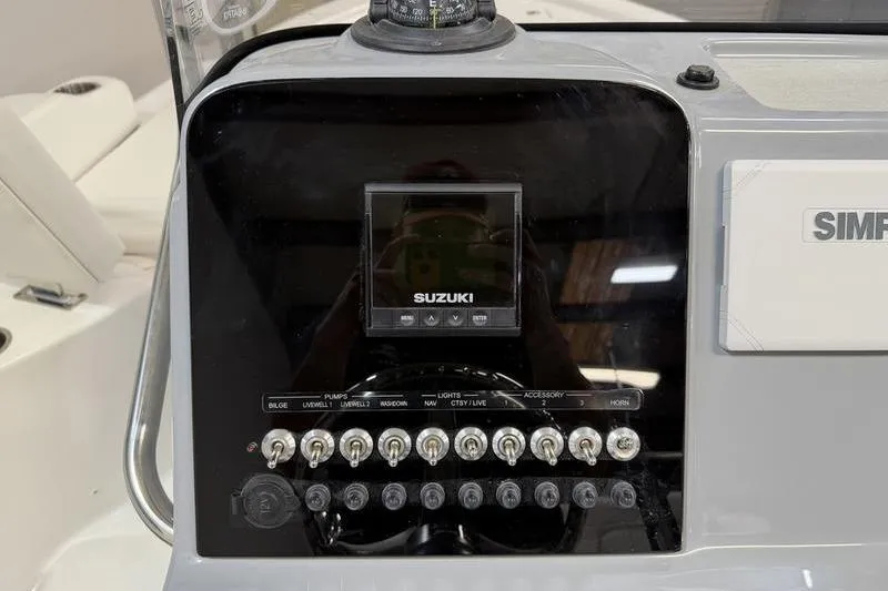 Slide: The Image of 2026 Sea Pro 210 Bay boat dashboard with Suzuki controls and switches. - 12