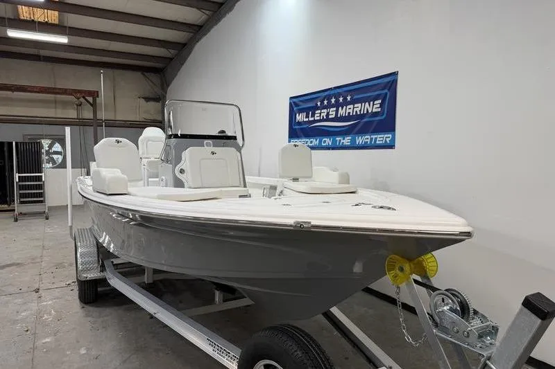 Slide: The Image of 2026 Sea Pro 210 Bay boat in showroom, displayed on a trailer. - 2