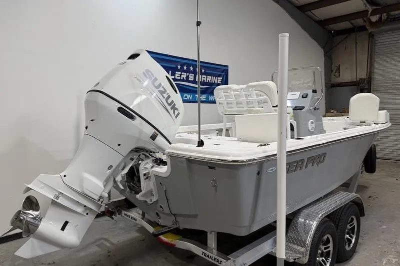 Slide: The Image of 2026 Sea Pro 210 Bay boat with Suzuki outboard motor on trailer in a garage. - 3