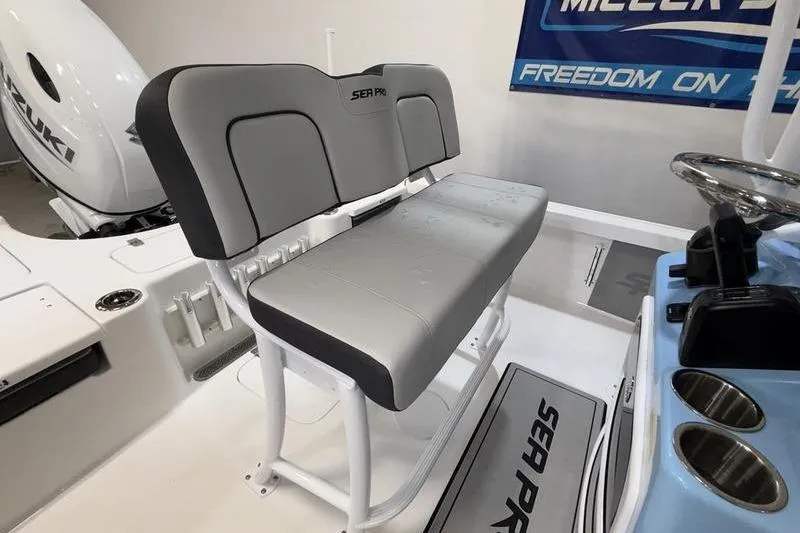 Slide: The Image of 2026 Sea Pro 210 Bay boat interior with gray seating and Suzuki engine. - 11