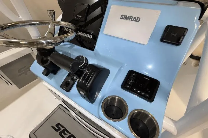 Slide: The Image of 2026 Sea Pro 210 Bay boat console with Simrad electronics and steering wheel. - 13