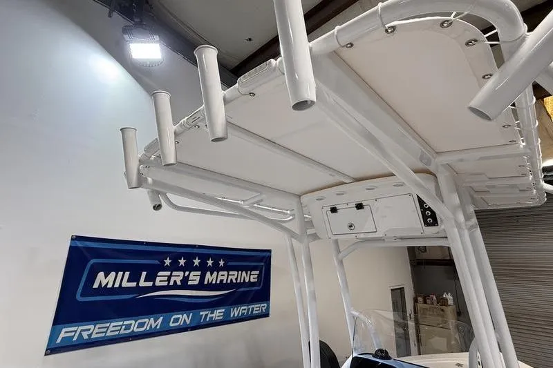 Slide: The Image of 2026 Sea Pro 210 Bay boat with rod holders, displayed at Miller's Marine showroom. - 14