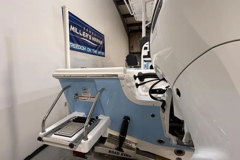 Slide: The Image of 2026 Sea Pro 210 Bay boat with ladder and motor, displayed at Miller's Marine showroom. - 4