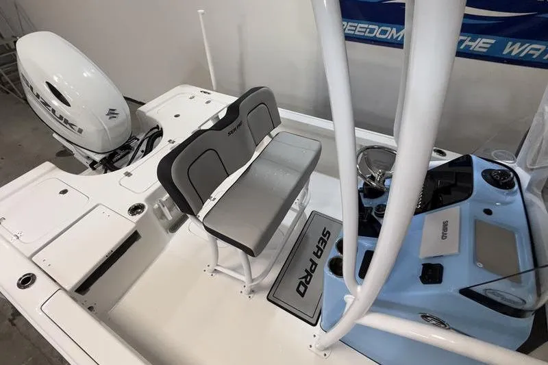 Slide: The Image of 2026 Sea Pro 210 Bay boat interior with seating and console, featuring Suzuki outboard motor. - 9