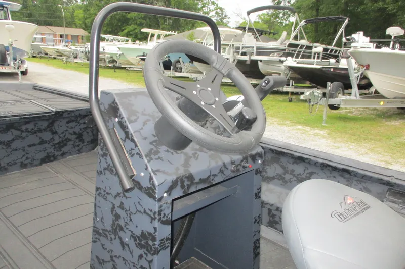 Slide: The Image of 2026 Gator Tail 1860 Extreme CC boat steering console with camouflage design in a marina setting. - 8