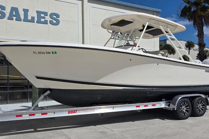 The Image of 2010 Pursuit S 280 Sport boat on trailer outside sales building. - 1