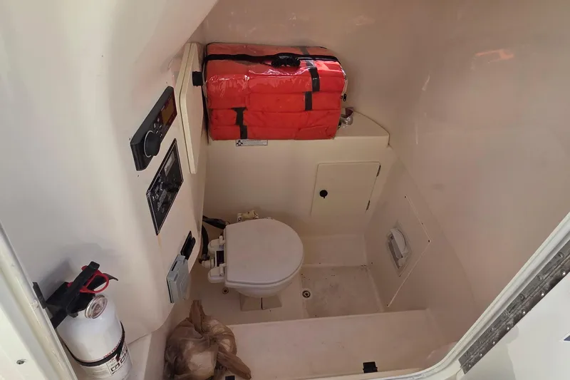 Slide: The Image of Interior of 2010 Pursuit S 280 Sport boat with toilet and safety equipment. - 13