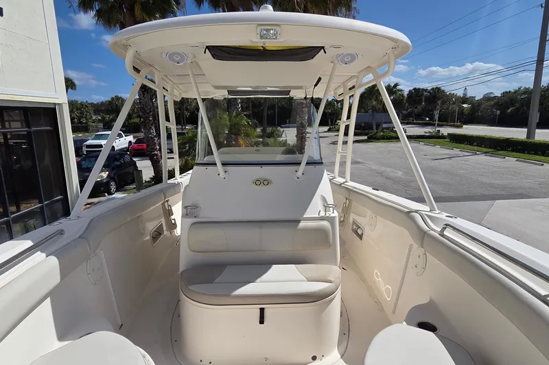 Slide: The Image of 2010 Pursuit S 280 Sport boat interior with seating and canopy under clear sky. - 14