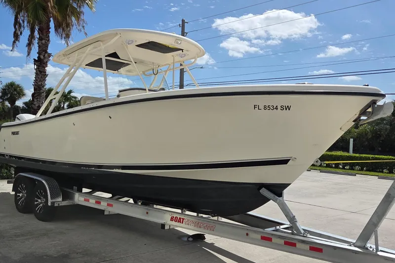 Slide: The Image of 2010 Pursuit S 280 Sport boat on trailer, parked outdoors under a clear sky. - 18