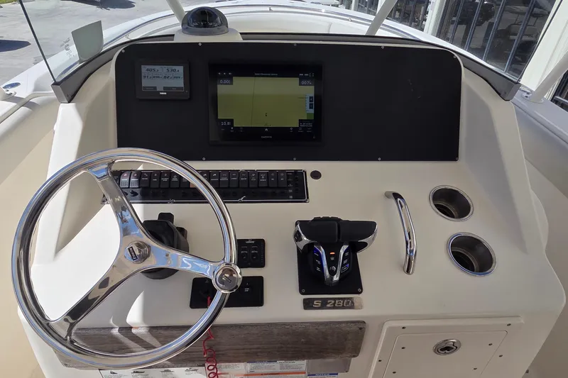 Slide: The Image of Helm of 2010 Pursuit S 280 Sport boat with steering wheel and navigation controls. - 4