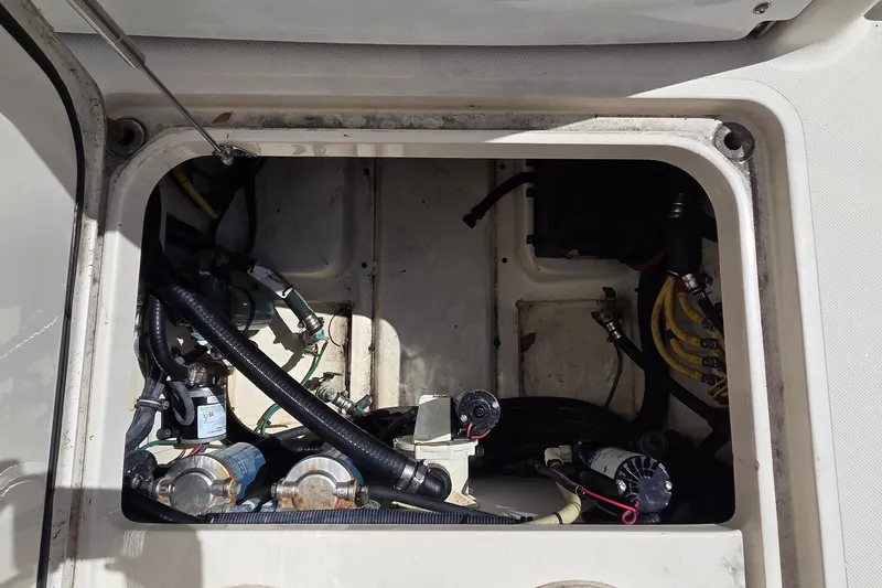 Slide: The Image of 2010 Pursuit S 280 Sport boat engine compartment with visible hoses and components. - 6
