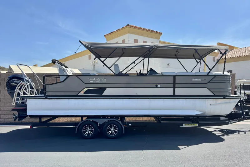 The Image of 2023 SunCatcher Elite 326 SE pontoon boat on trailer, parked outdoors. - 0