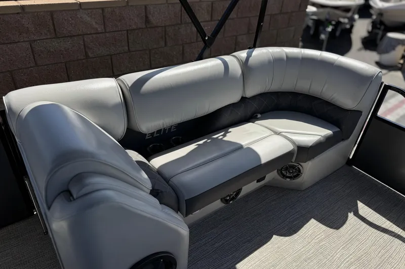 Slide: The Image of 2023 SunCatcher Elite 326 SE boat interior with plush gray seating and cup holders. - 12