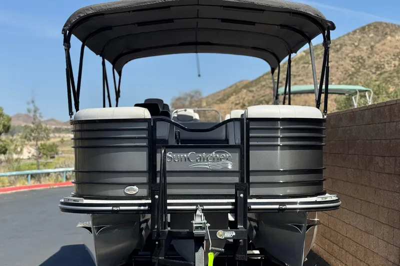 Slide: The Image of 2023 SunCatcher Elite 326 SE pontoon boat with canopy, parked outdoors. - 2