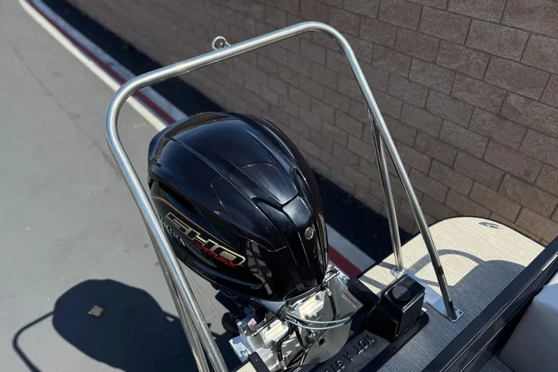 Slide: The Image of 2023 SunCatcher Elite 326 SE boat engine with protective frame, parked near brick wall. - 23