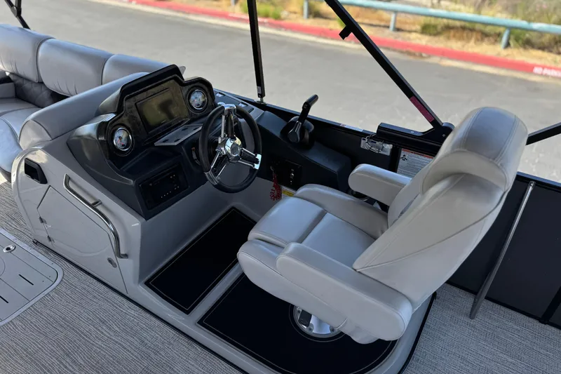 Slide: The Image of 2023 SunCatcher Elite 326 SE boat cockpit with steering wheel and captain's chair. - 25