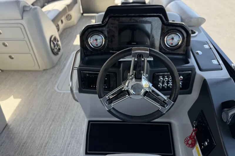 Slide: The Image of 2023 SunCatcher Elite 326 SE boat dashboard with steering wheel and gauges. - 26