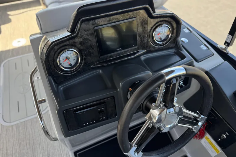 Slide: The Image of 2023 SunCatcher Elite 326 SE boat dashboard with steering wheel and gauges. - 27