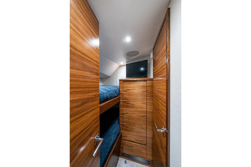 Slide: The Image of Interior of 2026 Viking 54 Convertible with bunk beds and wood paneling. - 48