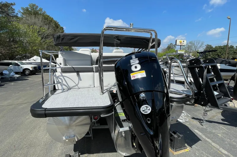 Slide: The Image of 2026 Harris Cruiser 230 SLDH pontoon boat with powerful 150 HP engine, parked outdoors. - 2