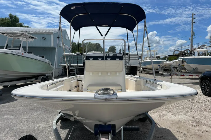 Slide: The Image of 2023 Boston Whaler 150 Montauk boat with canopy, parked outdoors under a blue sky. - 3