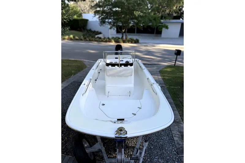 Slide: The Image of 2023 Boston Whaler 150 Montauk boat on trailer with blue canopy, parked outdoors. - 4