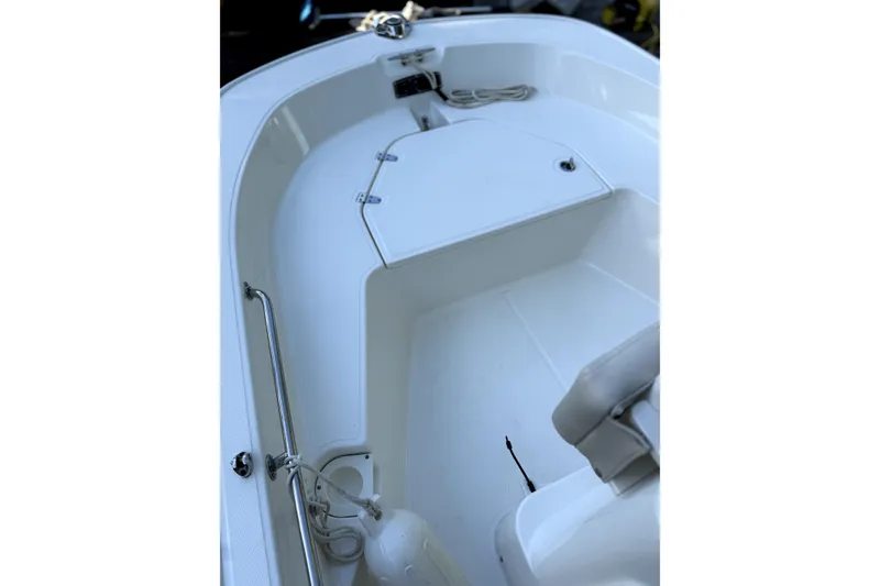 Slide: The Image of 2023 Boston Whaler 150 Montauk boat on trailer with canopy, parked outdoors. - 5