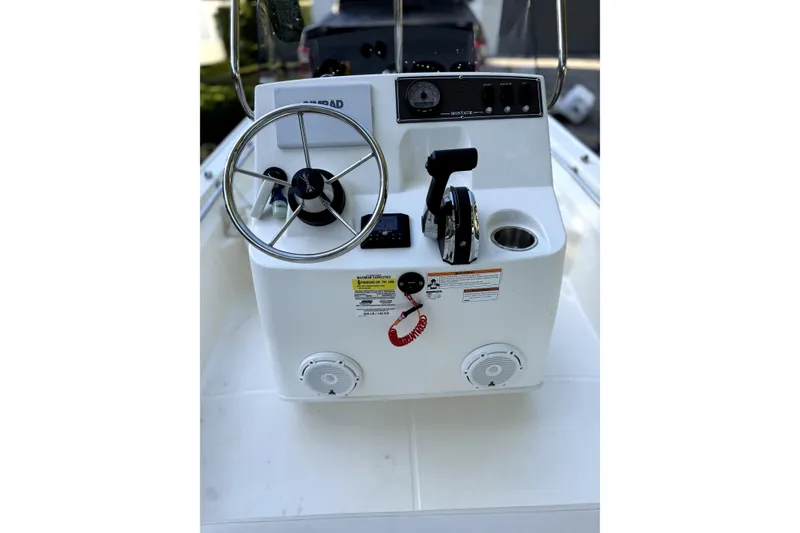 Slide: The Image of 2023 Boston Whaler 150 Montauk boat with 60 HP engine, parked outdoors. - 6