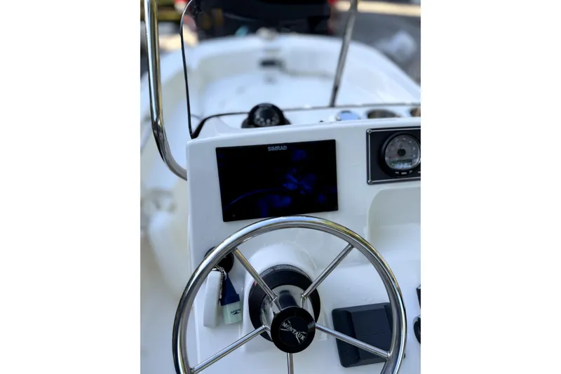 Slide: The Image of 2023 Boston Whaler 150 Montauk boat interior with Mercury engine and seating area. - 8
