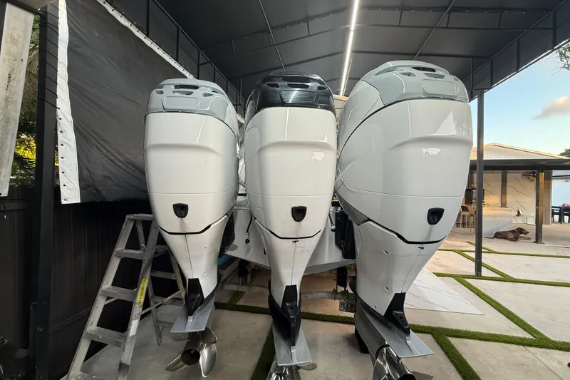 Slide: The Image of Three powerful outboard motors on a 2005 Formula 330 Sun Sport boat under a canopy. - 23