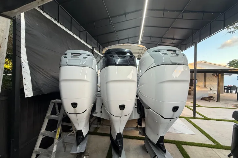 Slide: The Image of Three outboard motors on a 2005 Formula 330 Sun Sport under a canopy. - 24