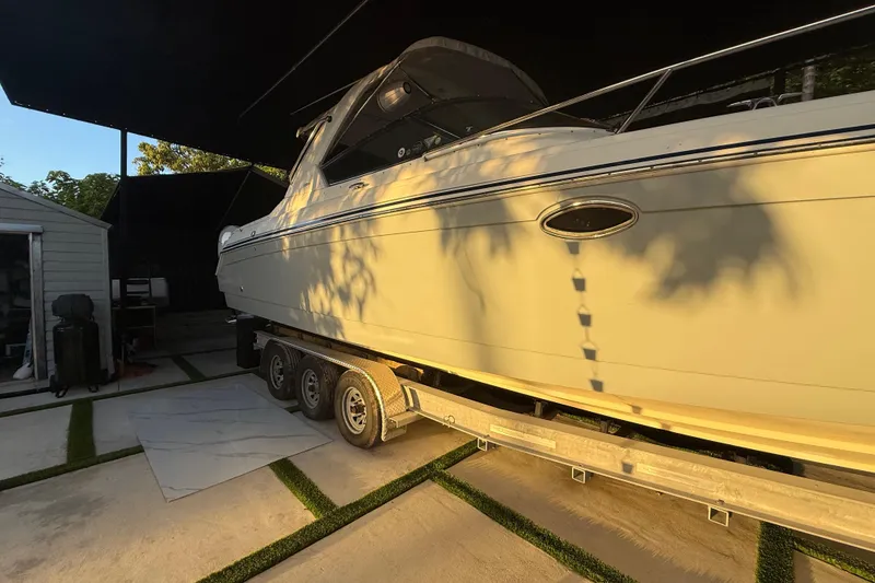 Slide: The Image of 2005 Formula 330 Sun Sport boat on trailer in shaded outdoor area. - 4