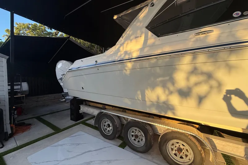 Slide: The Image of 2005 Formula 330 Sun Sport boat on trailer in shaded outdoor area. - 5