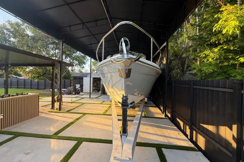 Slide: The Image of 2005 Formula 330 Sun Sport boat parked under a modern canopy in a landscaped yard. - 8