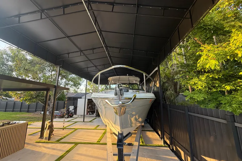 Slide: The Image of 2005 Formula 330 Sun Sport boat under a covered dock, surrounded by trees. - 9