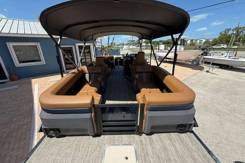 Slide: The Image of 2026 Bennington 22 M Quad Bench pontoon boat with brown seating and canopy. - 4