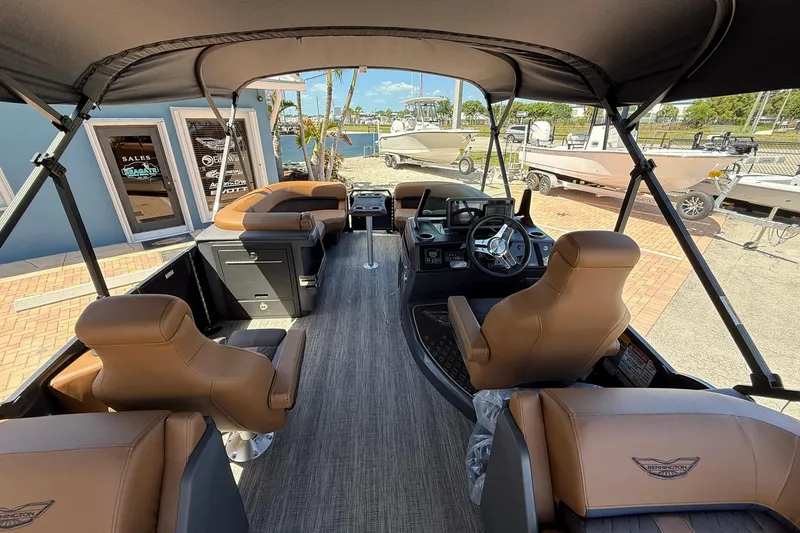 Slide: The Image of 2026 Bennington 22 M Quad Bench boat interior with tan seating and modern dashboard. - 6