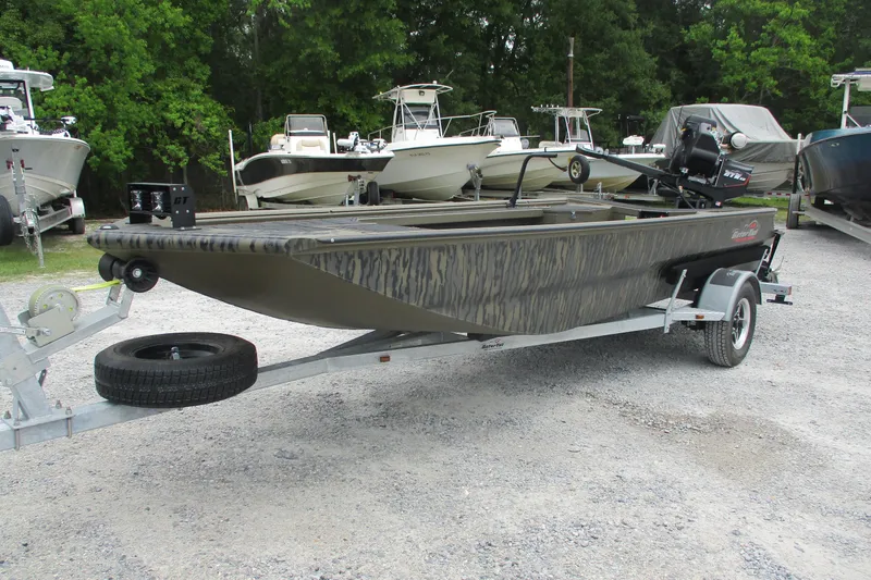 Slide: The Image of 2026 Gator Tail 1854 Extreme boat on trailer, parked in a lot with other boats. - 5