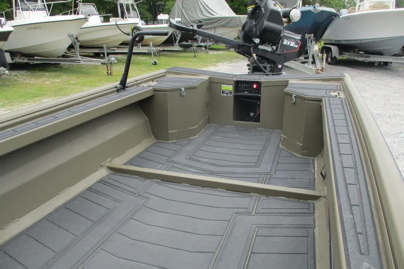 Slide: The Image of 2026 Gator Tail 1854 Extreme boat interior with durable flooring and motor, parked among other boats. - 7