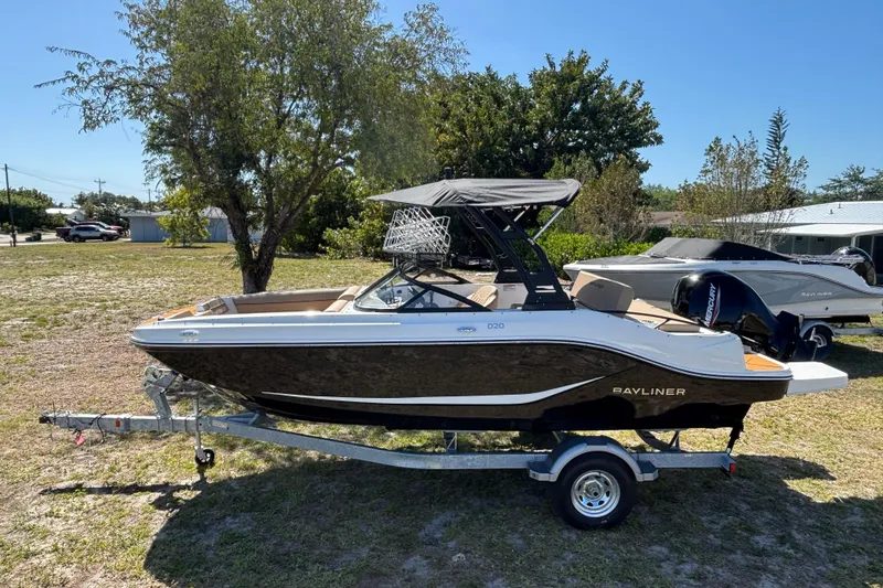 The Image of 2026 Bayliner D20 boat on trailer, parked outdoors under clear sky. - 0