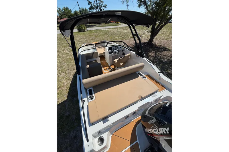 Slide: The Image of 2026 Bayliner D20 boat with tan seating and Mercury outboard motor. - 6