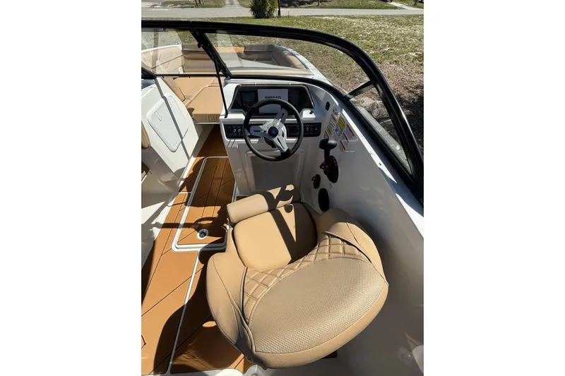 Slide: The Image of Interior view of 2026 Bayliner D20 boat, featuring tan seating and modern dashboard controls. - 7