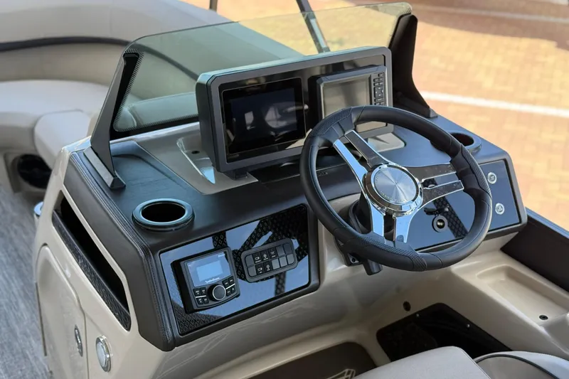 Slide: The Image of 2026 Bennington 22 M Swingback boat dashboard with steering wheel and digital displays. - 13
