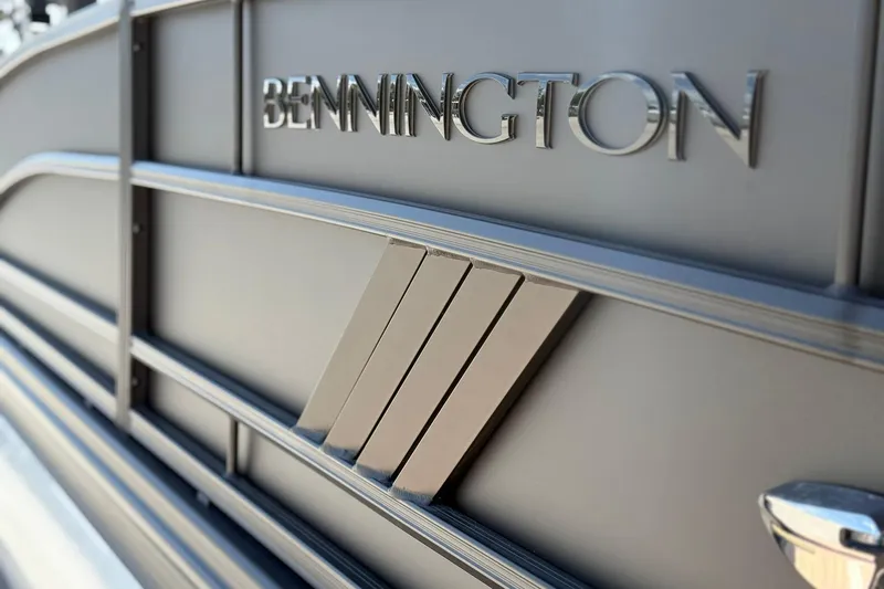 Slide: The Image of 2026 Bennington 22 M Swingback boat exterior with logo detail. - 2