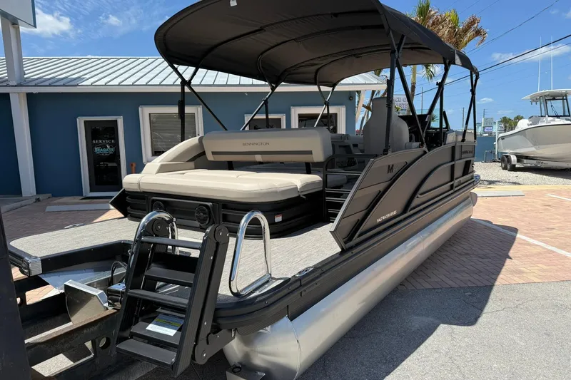 Slide: The Image of 2026 Bennington 22 M Swingback pontoon boat with canopy, parked outdoors. - 4