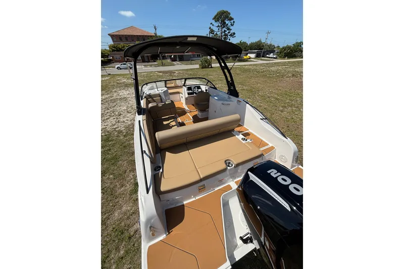 Slide: The Image of 2026 Bayliner D22 boat with tan seating and sleek design, parked on grass. - 11