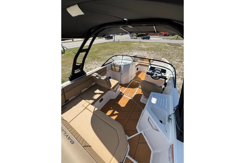 Slide: The Image of 2026 Bayliner D22 boat interior with tan seating, steering console, and open deck layout. - 13