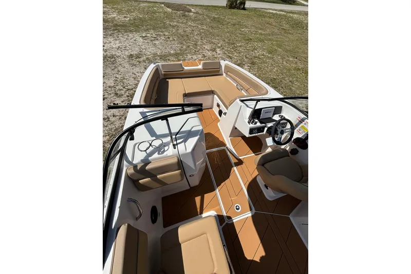 Slide: The Image of 2026 Bayliner D22 boat interior with tan seating and modern dashboard. - 18